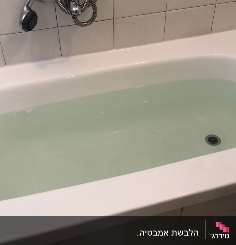 אמבטיה מלאה במים עם ברז ומקלחת